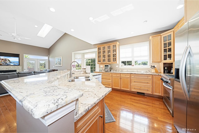 18011 Breckenridge Blvd, Orland Park, IL 60467 - kitchen with stainless steel appliances, light brown cabinets, a skylight, a center island with sink, and light wood-style floors