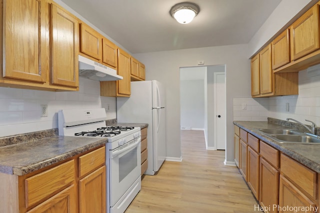 2029 Gabriel Ave, Zion, IL 60099 - kitchen with white appliances, under cabinet range hood, backsplash, and dark countertops
