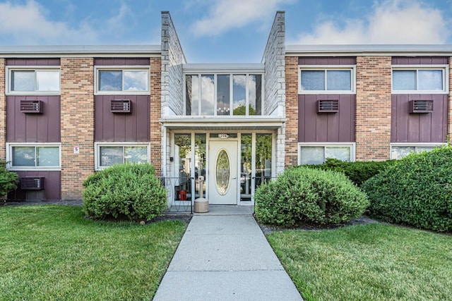 120A Collen Dr Unit 105, Lombard, IL 60148 - view of front of house featuring a front yard, brick siding, a wall mounted AC, and board and batten siding
