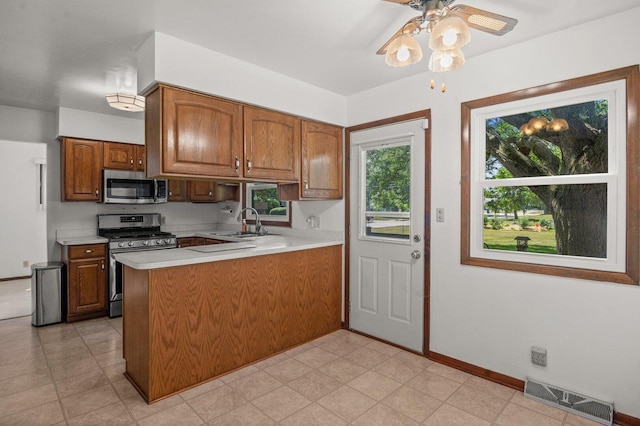 308 Long Ave, North Aurora, IL 60542 - kitchen with stainless steel appliances, light countertops, a peninsula, brown cabinetry, and a ceiling fan