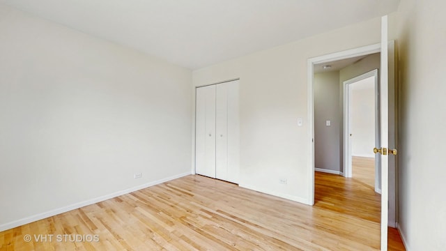 unfurnished bedroom with light wood finished floors and a closet