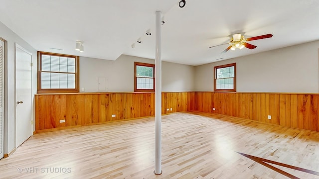 1828 Wicker St, Woodstock, IL 60098 - unfurnished room featuring wainscoting, wood finished floors, wooden walls, and ceiling fan