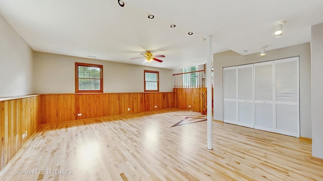 1828 Wicker St, Woodstock, IL 60098 - unfurnished bedroom featuring a wainscoted wall, wood finished floors, wood walls, a closet, and ceiling fan
