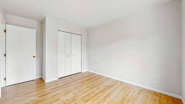 empty room featuring wainscoting, wood finished floors, wooden walls, and a ceiling fan