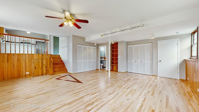 unfurnished bedroom with wood finished floors and two closets