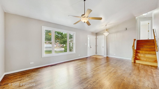 1828 Wicker St, Woodstock, IL 60098 - unfurnished living room with wood finished floors, stairway, a ceiling fan, and vaulted ceiling