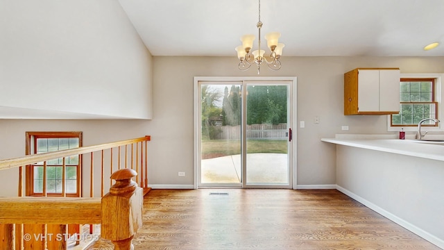 unfurnished dining area featuring a chandelier and wood finished floors