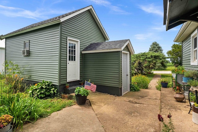 28231 US Highway 150, Leroy, IL 61752 - view of property exterior featuring entry steps, a shingled roof, cooling unit, a shed, and a patio area