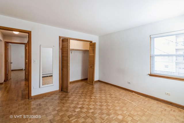 837 N Harlem Ave Unit 2N, Oak Park, IL 60302 - unfurnished bedroom featuring a baseboard heating unit, multiple windows, and a closet