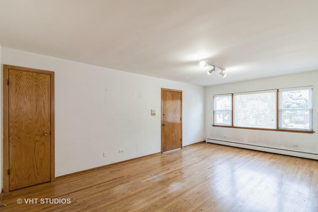 837 N Harlem Ave Unit 2N, Oak Park, IL 60302 - empty room featuring a baseboard heating unit, light wood-type flooring, and rail lighting
