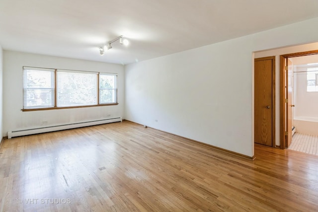 837 N Harlem Ave Unit 2N, Oak Park, IL 60302 - unfurnished room with a baseboard radiator, light wood-style flooring, plenty of natural light, and rail lighting