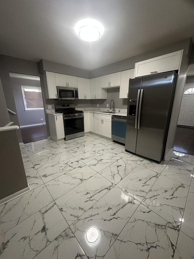 933 E 142nd St, Dolton, IL 60419 - kitchen with appliances with stainless steel finishes, light countertops, white cabinets, and light marble finish flooring