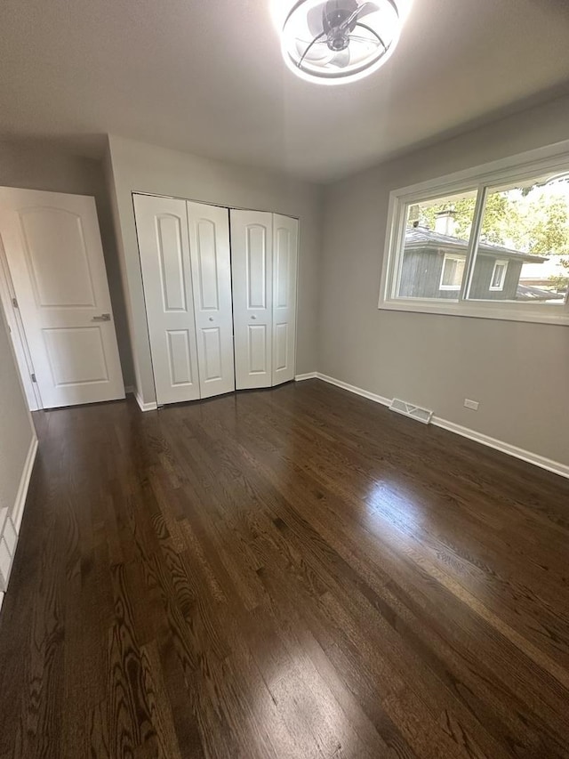 933 E 142nd St, Dolton, IL 60419 - unfurnished bedroom with dark wood finished floors and a closet