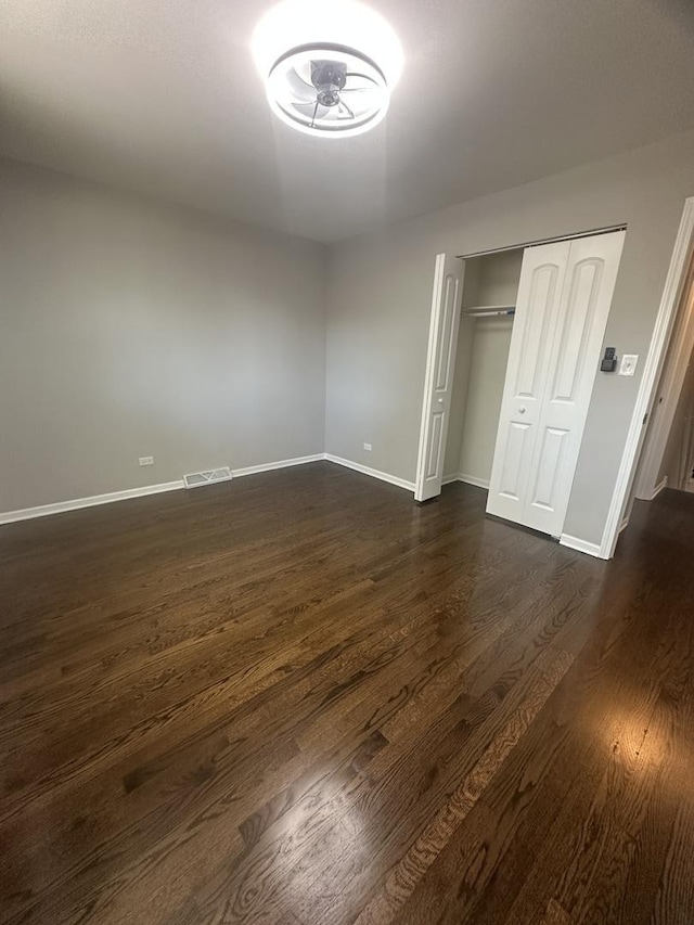 933 E 142nd St, Dolton, IL 60419 - unfurnished bedroom with dark wood-type flooring and a closet