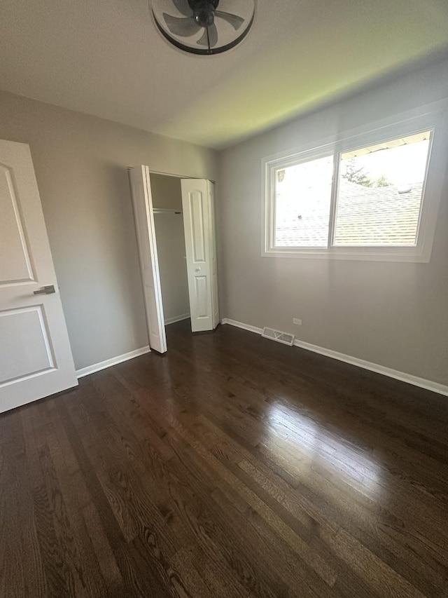 933 E 142nd St, Dolton, IL 60419 - unfurnished bedroom with dark wood-type flooring and a closet