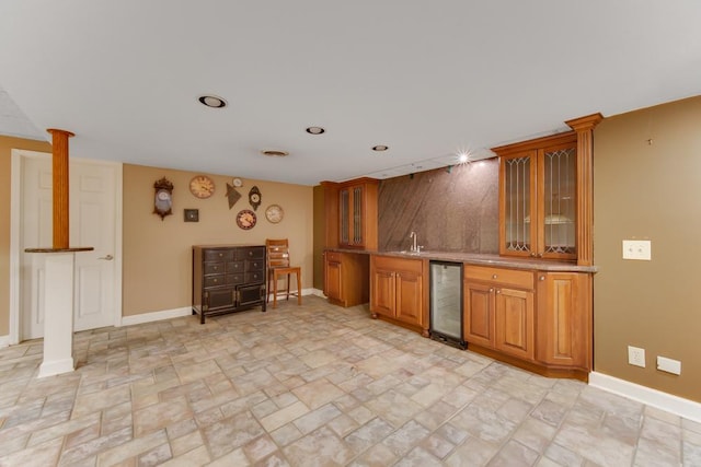 1234 Will Dr, Lockport, IL 60441 - kitchen featuring beverage cooler, brown cabinets, glass insert cabinets, and decorative columns