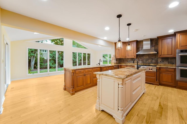 1234 Will Dr, Lockport, IL 60441 - kitchen featuring wall chimney exhaust hood, appliances with stainless steel finishes, light wood-type flooring, lofted ceiling, and a center island with sink