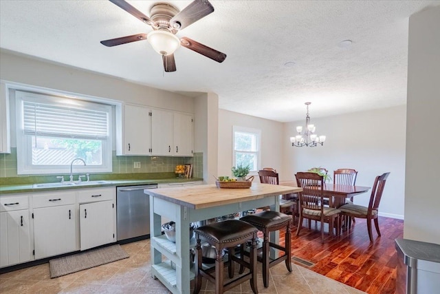 107 S Regency Dr, Bloomington, IL 61701 - kitchen with dishwasher, backsplash, a chandelier, white cabinets, and a textured ceiling