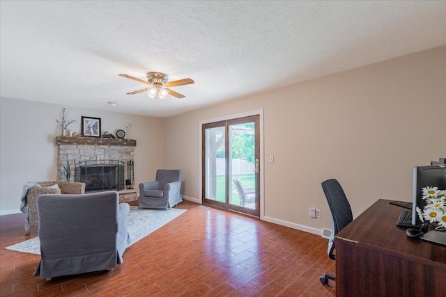 107 S Regency Dr, Bloomington, IL 61701 - living room with a ceiling fan, wood finished floors, a fireplace, a desk, and a textured ceiling