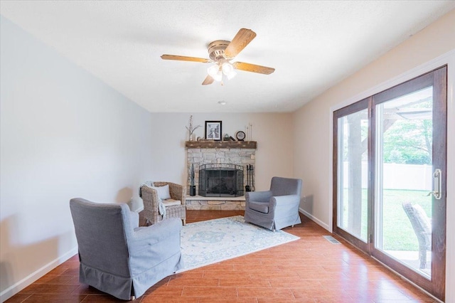 107 S Regency Dr, Bloomington, IL 61701 - living area with healthy amount of natural light, a stone fireplace, and wood finished floors