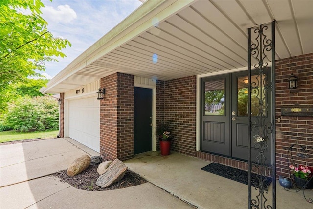 107 S Regency Dr, Bloomington, IL 61701 - view of exterior entry with brick siding, a garage, and concrete driveway