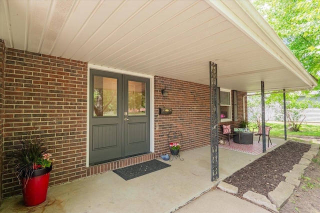 107 S Regency Dr, Bloomington, IL 61701 - doorway to property with covered porch, brick siding, and french doors