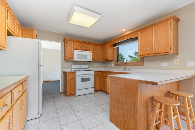 641 Downing St, New Lenox, IL 60451 - kitchen featuring white appliances, a peninsula, light countertops, a kitchen breakfast bar, and recessed lighting