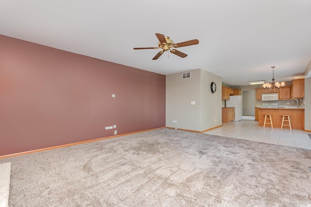 641 Downing St, New Lenox, IL 60451 - unfurnished living room featuring a chandelier, light colored carpet, and ceiling fan