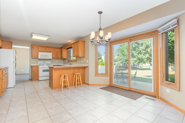 641 Downing St, New Lenox, IL 60451 - kitchen with white appliances, a chandelier, healthy amount of natural light, and light countertops