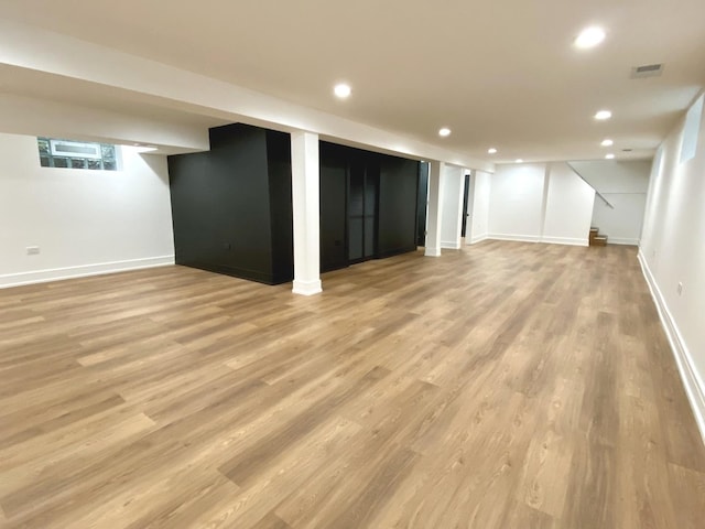 finished below grade area with light wood-style floors, recessed lighting, and stairway