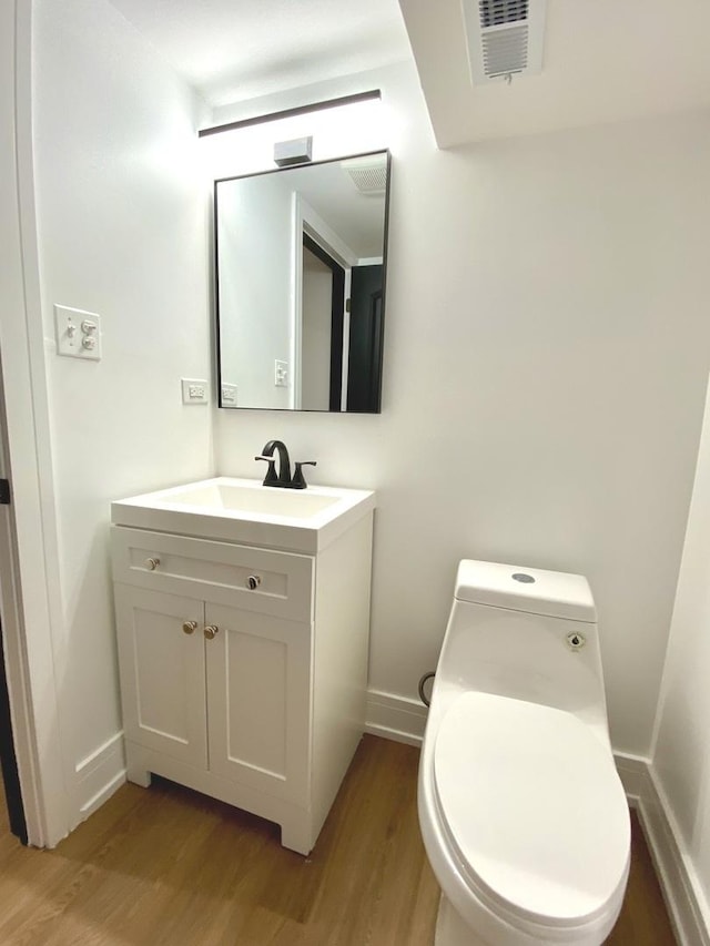 half bath with wood finished floors and vanity