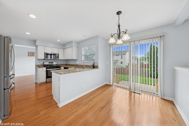 474 Wildflower Way, Bolingbrook, IL 60440 - kitchen with appliances with stainless steel finishes, a peninsula, light wood-style flooring, a chandelier, and recessed lighting