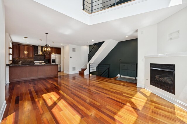 1701 N Washtenaw Ave Unit 1E, Chicago, IL 60647 - living room with light wood-style floors, stairway, a fireplace, a chandelier, and recessed lighting