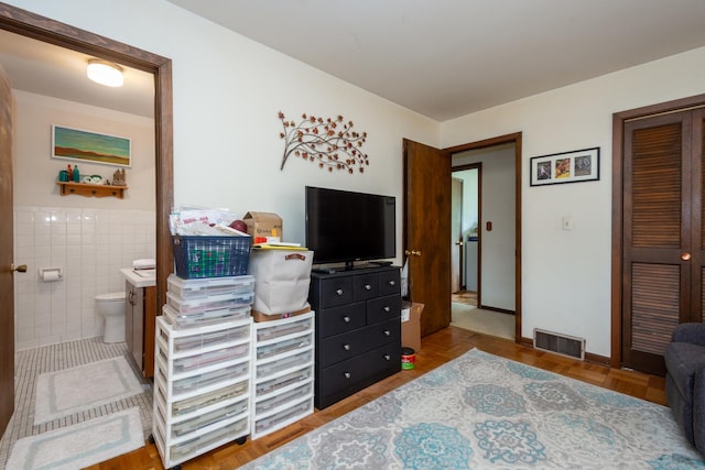 874 Hillandale Dr, Antioch, IL 60002 - bedroom featuring ensuite bathroom, tile walls, a closet, and wainscoting