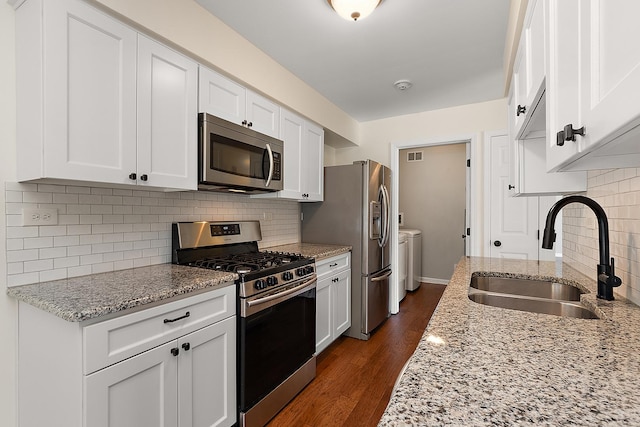 2725 Weeping Willow Dr Unit D, Lisle, IL 60532 - kitchen featuring appliances with stainless steel finishes, washing machine and clothes dryer, white cabinetry, backsplash, and dark wood-style flooring
