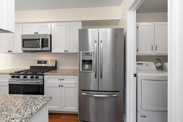 2725 Weeping Willow Dr Unit D, Lisle, IL 60532 - kitchen featuring appliances with stainless steel finishes, washer / clothes dryer, white cabinetry, and light stone counters