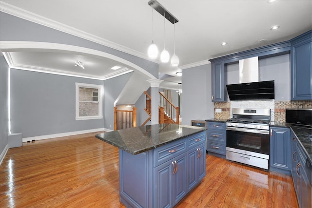 5151 W Fletcher St, Chicago, IL 60641 - kitchen with gas range, blue cabinets, ventilation hood, ornate columns, and decorative backsplash