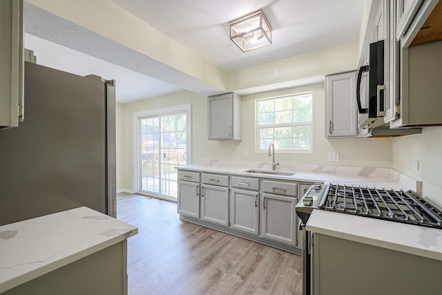 413 Channel Dr, Island Lake, IL 60042 - kitchen featuring appliances with stainless steel finishes, light wood-style flooring, light stone countertops, and healthy amount of natural light