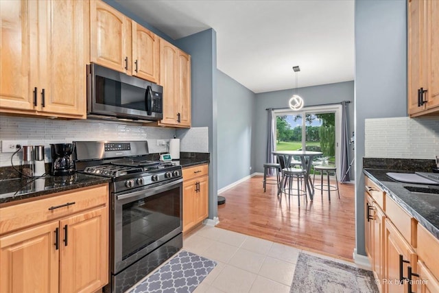 9196 Falcon Greens Dr, Lakewood, IL 60014 - kitchen with appliances with stainless steel finishes, light brown cabinets, tasteful backsplash, light tile patterned floors, and dark stone counters