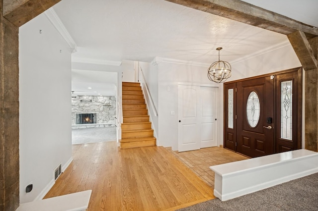 2425 N Drury Ln, Arlington Heights, IL 60004 - foyer featuring light wood-style flooring, stairs, ornamental molding, a chandelier, and a fireplace