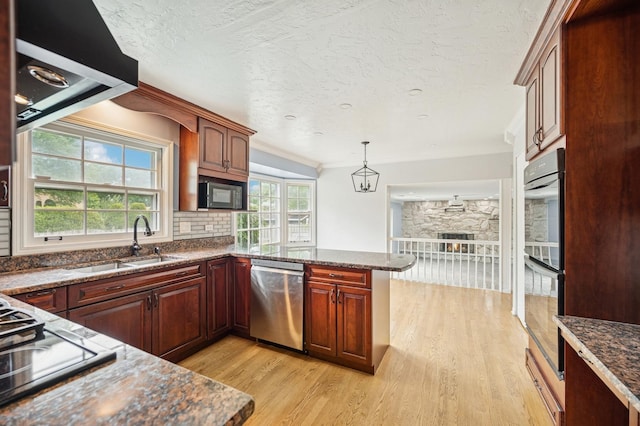 2425 N Drury Ln, Arlington Heights, IL 60004 - kitchen with stainless steel appliances, light wood-style floors, a peninsula, dark stone countertops, and a textured ceiling