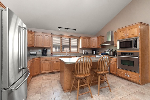 8542 Monaghan Dr, Tinley Park, IL 60487 - kitchen featuring appliances with stainless steel finishes, wall chimney exhaust hood, a kitchen island, light tile patterned flooring, and lofted ceiling