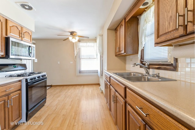 205 W 29th Pl S, Chicago Heights, IL 60411 - kitchen with black range with gas stovetop, stainless steel microwave, backsplash, a ceiling fan, and light countertops