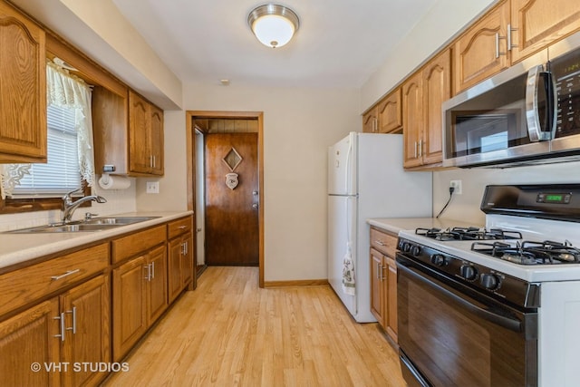 205 W 29th Pl S, Chicago Heights, IL 60411 - kitchen with black range with gas stovetop, stainless steel microwave, brown cabinets, light wood finished floors, and light countertops