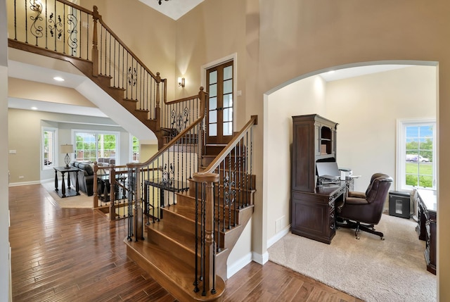 18013 Saint Andrews Dr, Marengo, IL 60152 - stairs featuring a high ceiling, arched walkways, wood finished floors, and recessed lighting
