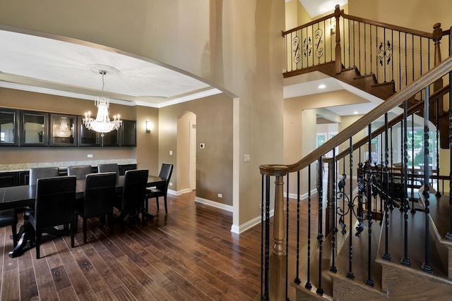 18013 Saint Andrews Dr, Marengo, IL 60152 - dining area with arched walkways, stairs, a chandelier, dark wood-style flooring, and ornamental molding