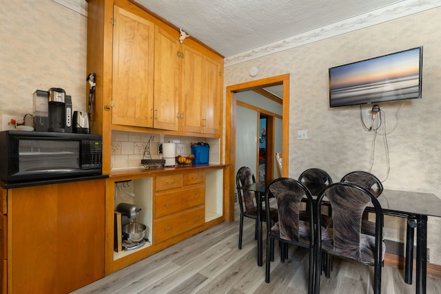 1314 Wesley Ave, Berwyn, IL 60402 - kitchen featuring black microwave, light wood finished floors, tasteful backsplash, a textured ceiling, and brown cabinetry