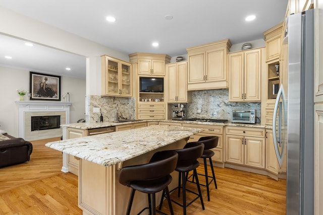 290 Knox Park Rd, Lake Zurich, IL 60047 - kitchen featuring appliances with stainless steel finishes, a kitchen bar, light stone countertops, decorative backsplash, and recessed lighting