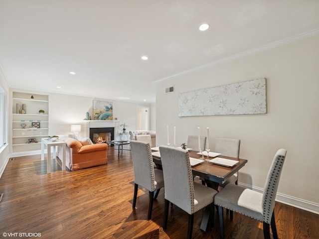 622 Kenilworth Ave, Kenilworth, IL 60043 - dining room featuring crown molding, wood finished floors, a warm lit fireplace, recessed lighting, and built in shelves