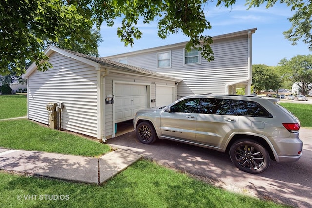 1320 N Glen Cir Unit B, Aurora, IL 60506 - view of property exterior featuring an attached garage, driveway, and a lawn